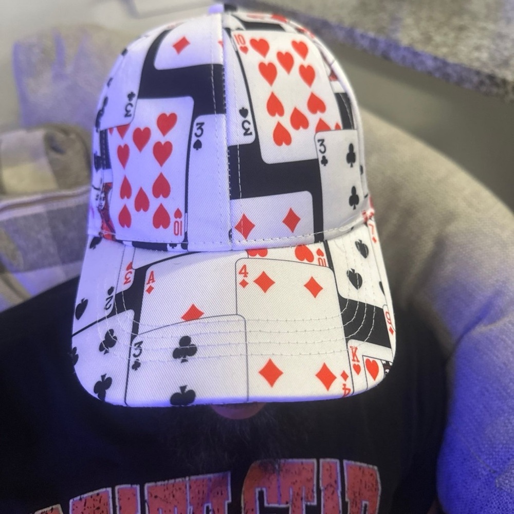 The white baseball cap pattern featuring hearts, clubs, spades, and diamonds.